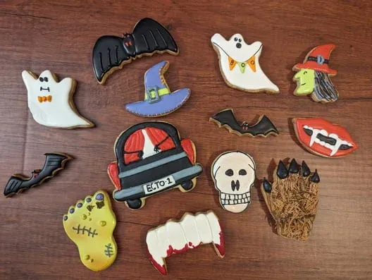 Decorated Halloween sugar cookies laid out on wood