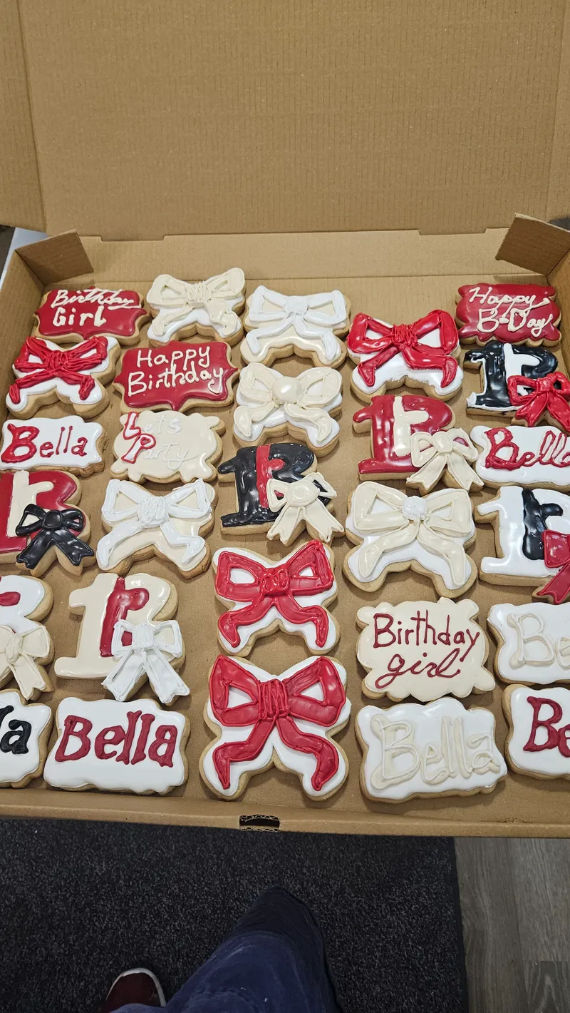 Pink and red bow cookies with a name in a bakery box